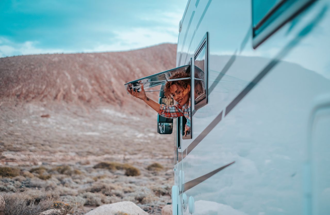 Woman enjoying the view from an RV window in the desert